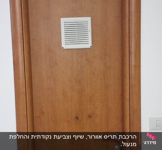 דלת עץ עם ידית מתכת ופתח אוורור